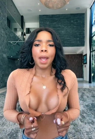 Erotic Teala Dunn Shows Cleavage in Peach Top